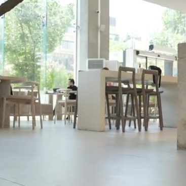 A cozy café featuring a large window and inviting chairs, creating a warm and welcoming atmosphere for patrons