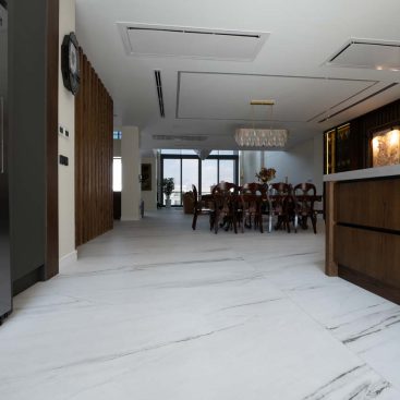 A modern kitchen featuring elegant marble flooring and a stylish dining table, creating a sophisticated dining space.